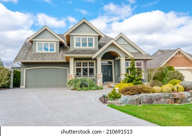 Luxury House With A Two-car Garage And Beautiful Landscaping On A Sunny Day. Home Exterior.