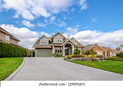 Luxury House With A Two-car Garage And Beautiful Landscaping On A Sunny Day. Home Exterior.