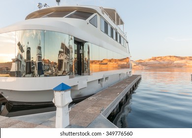 Luxury Houseboat At Pier On Lake Powell With Window Reflections Of Boats And Red Rock Cliffs Across Lake Arizona USA