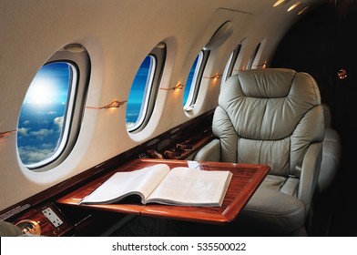 Luxury Interior In The Modern  Business Jet And Sunlight At The Window/sky And Clouds Through The Porthole