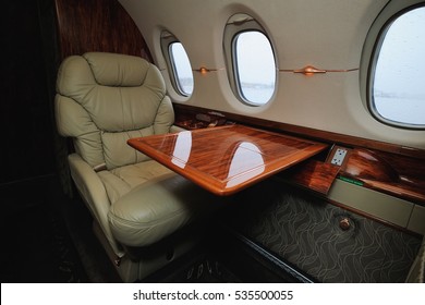 Luxury Interior In The Modern  Business Jet And Sunlight At The Window/sky And Clouds Through The Porthole