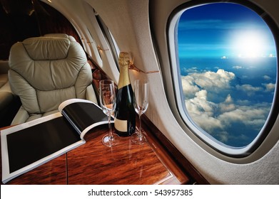 Luxury Interior In The Modern  Business Jet And Sunlight At The Window/sky And Clouds Through The Porthole