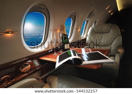 luxury interior in the modern  business jet and sunlight at the window/sky and clouds through the porthole 商業照片 © 
