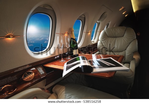 luxury interior in the\
modern  business jet and sunlight at the window/sky and clouds\
through the porthole