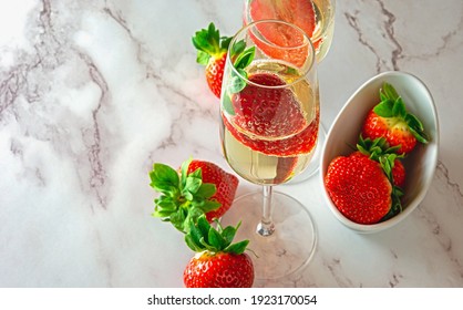 Luxury Lifestyle Drinking Fresh Juicy Strawberry In A Glass Of Golden Champagne Decorated With Strawberries. Romantic Drink To Celebration After Work Together At Home. Drink After Work At Home