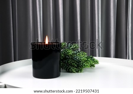 luxury lighting black glass aromatic scented candle is on white steel table with green plant to creat relax ambient in the bedroom with background of nice bedroom and grey curtain on Valentine day