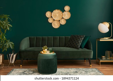 Luxury living room in house with modern interior design, green velvet sofa, coffee table, pouf, gold decoration, plant, lamp, carpet and elegant personal accessories. Template.