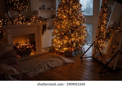 Luxury Living Room Interior Decorated With Chic Christmas Tree. Warm Cozy Evening. Xmas Tree Decorated Lights Gifts, Deer, Candles, Lanterns, Garland Lighting, Floor Mirror, Fireplace.