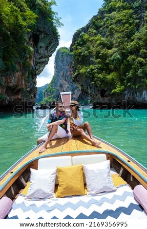 Luxury Longtail boat in Krabi Thailand, couple man, and woman on a trip at the tropical island 4 Island trip in Krabi Thailand. Asian woman and European man mid age on vacation in Thailand. 