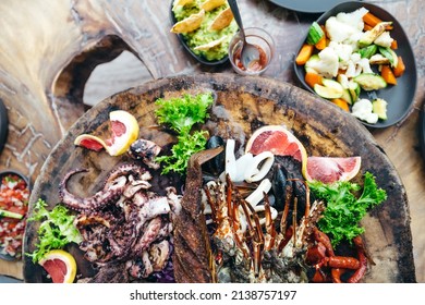 luxury lunch served on a wooden tray with lobster and seafood at a beach club in tulum mexico