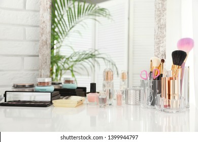 Luxury makeup products and accessories on dressing table with mirror. Space for text