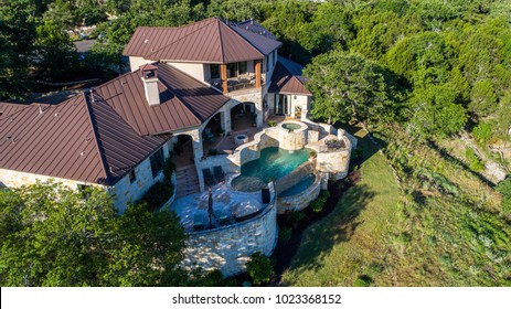 Luxury Mansion On Large Lot Of Land With Texas Hill Country Landscape And Surrounding Green Surroundings Of The Ranch Country Home With Infinity Pool And Wealthy Real Estate Living Side View Of Home