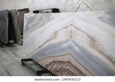 Luxury marble slabs in warehouse.
				Slabs arranged mirror-like. 