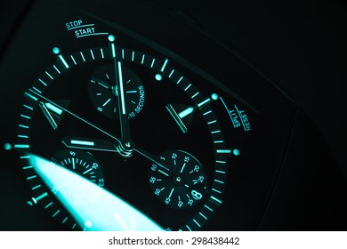 Luxury Mens Chronograph Watch, Clock Deal With Blue Green Illumination. Close-up Blue Toned Studio Photo With Selective Focus