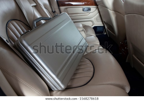 Luxury metal briefcase on the car back seat.\
Creme leather\
