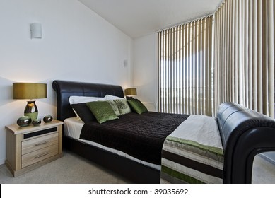luxury modern bedroom with a leather coated bed frame bedside tables and decoration