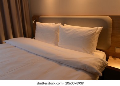 Luxury Modern Hotel Bedroom, No People, Cozy Warm Colors Cushions, Carpeting, Curtains, Wall Upholstery And Furnishings. Travel Vacation Relaxation Concept.