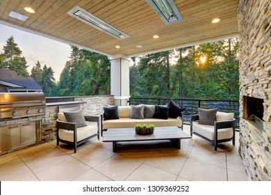 Luxury Modern House Exterior With Covered Patio Boasting Stone Fireplace And Cozy Rattan Furniture.
