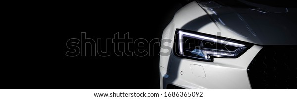 Luxury\
modern sport car with tinted headlights on black background. Copy\
space at left side. Car sales and tuning\
topic.