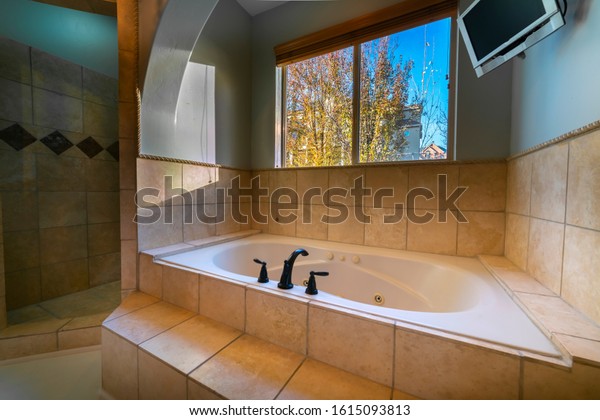 Luxury modern\
sunken bath with tiled\
surround