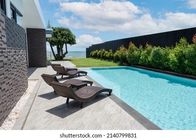 Luxury modern villa with sun loungers by poolside in tropical sea on vacation summer - Powered by Shutterstock