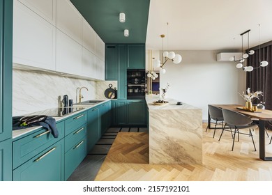 Luxury modern and vintage turquoise interior. Marble kitchen island with wooden chockers. Brown wooden table with metalic tray and metalic gold vase with white decorations.  - Shutterstock ID 2157192101
