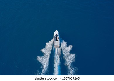 Luxury Motor Boat. Aerial View Of A Boat In Motion On Blue Water. Top View Of A White Boat Sailing In The Blue Sea. Drone View Of A Boat Sailing At High Speed.