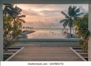 Luxury Outdoor Poolside, Infinity Swimming Pool With Palm Trees And Sunset Sky Close To Beach And Sea. Beautiful Resort Beach Pool, Tranquil Family Or Couple Summer Vacation Destination