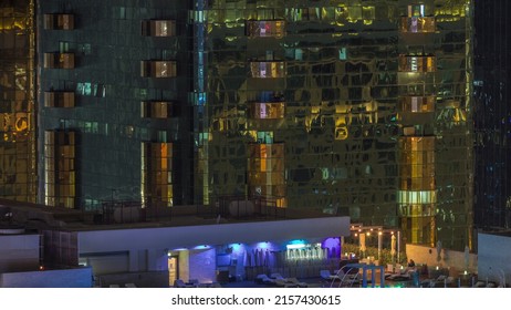 Luxury Outdoor Rooftop Swimming Pool And Relaxing Zone Around Aerial Night Timelapse. Top View With Skyscrapers Behind, Dubai