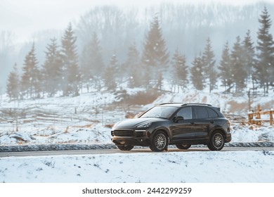 Luxury Performance Meets Winter Terrain. Black German SUV Embraces the Snowy Road. - Powered by Shutterstock