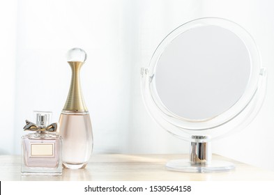 Luxury perfume bottles on wooden dressing table.
