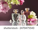 Luxury perfumes and floral decor on mirror surface against dark background