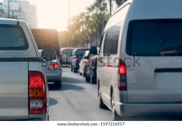 Luxury of pick up car stop on the\
asphalt road. Traveling in the provinces during on evening. \
Traffic jam after to work in an urban area. open brake\
light.