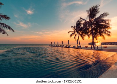 Luxury pool sunset, palm tree silhouette with windy infinity pool water surface. Summer vacation, holiday template. Stunning sky, beachfront hotel resort at tropical landscape tranquil. Amazing island