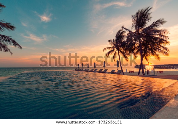 Luxury pool sunset, palm tree silhouette with\
windy infinity pool water surface. Summer vacation, holiday\
template. Stunning sky, beachfront hotel resort at tropical\
landscape tranquil. Amazing\
island