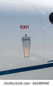 Luxury Private Jet Airplane Door. Exit Sign Over The Door Handle.