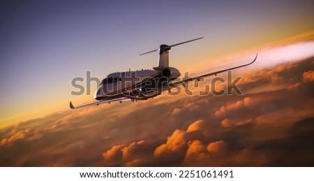 A luxury private jet airplane overflying cloudy skies at sunset