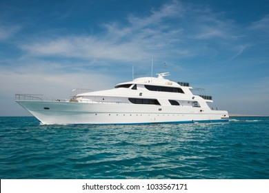 A luxury private motor yacht under way on tropical sea with bow wave - Shutterstock ID 1033567171