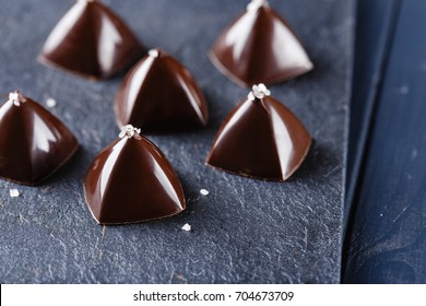 Luxury pyramid shaped chocolate candy on black background. Exclusive molded bonbons with salt decoration - Powered by Shutterstock