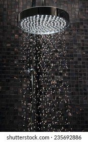 Luxury rain shower in domestic bathroom with falling water against Italian glass mosaics. The picture was taken with a high speed flash to freeze single drops.