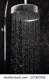 Luxury rain shower in domestic bathroom with falling water against Italian glass mosaics.