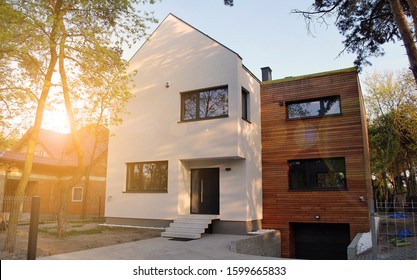 Luxury real estate single family house with wooden facade,  view during sunset.