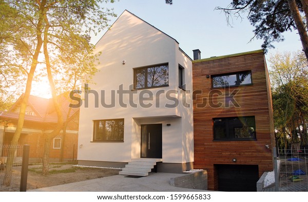 Luxury real estate single family house with\
wooden facade,  view during\
sunset.