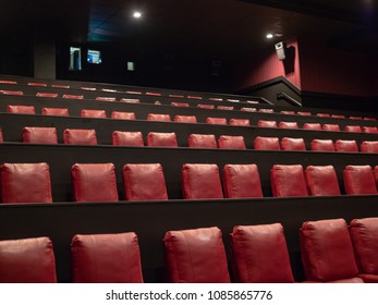 Luxury Red Movie Theater Seats In With A Projector On Background