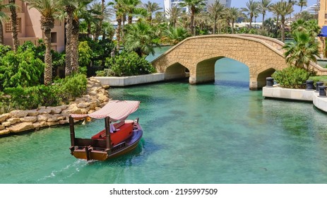 Luxury Relaxes Boat Trip On Traditional Arab Abra Skiff On Amazing Turquoise Of Madinat Jumeirah Canals. Popular Travel Landmark. Dubai,UAE.Aug.2022