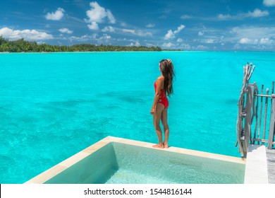 Luxury Resort Vacation Travel Woman Relaxing On Private Island Infinity Pool At Overwater Bungalow, Bora Bora, Tahiti, French Polynesia. Elegant Lady In One Piece Swimsuit At Turquoise Pristine Ocean.