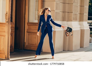 Luxury Rich Woman Dressed In Elegant Stylish Blue Suit Walking In City On Sunny Summer Day Holding Purse, Fashion Trend