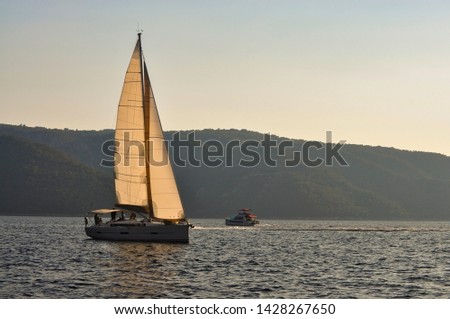Luxury sailing boat is sailing on calm sea but have some wind in the sails