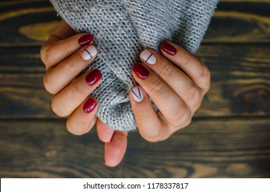 Luxury short manicure Burgundy dark wooden background  cozy autumn nails 