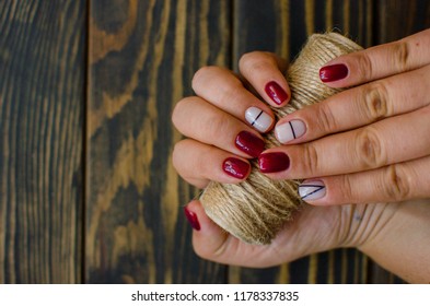 Luxury short manicure Burgundy dark wooden background  cozy autumn nails 